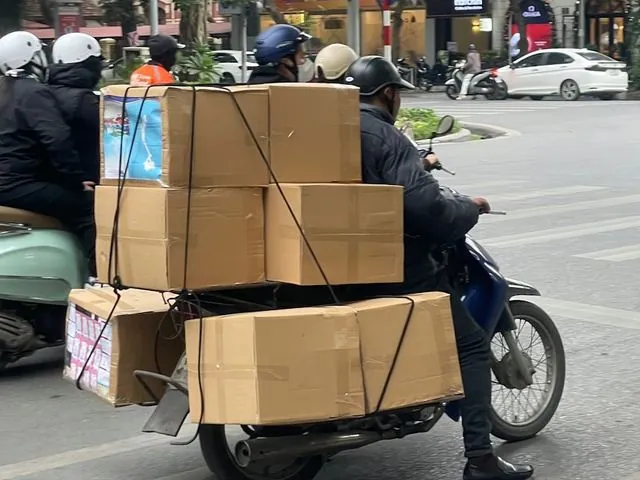 Moto carregando caixas de papelão na rua